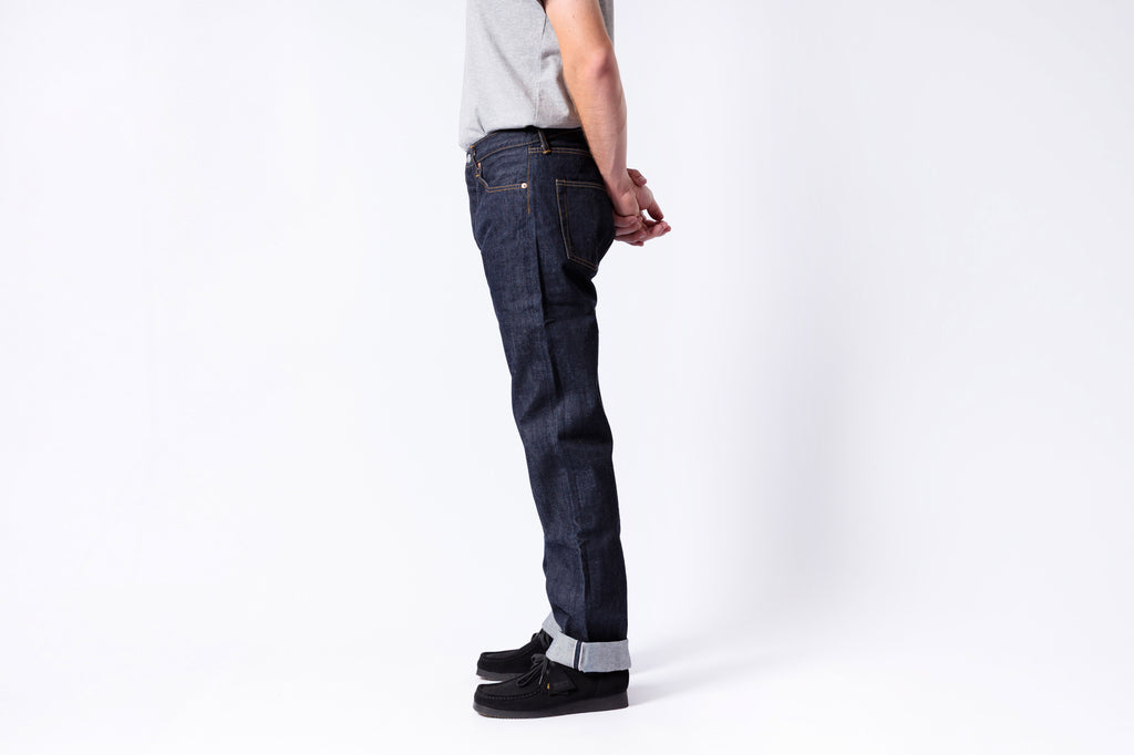 Person wearing dark blue jeans on a white background