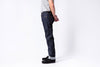 Person wearing dark blue jeans on a white background