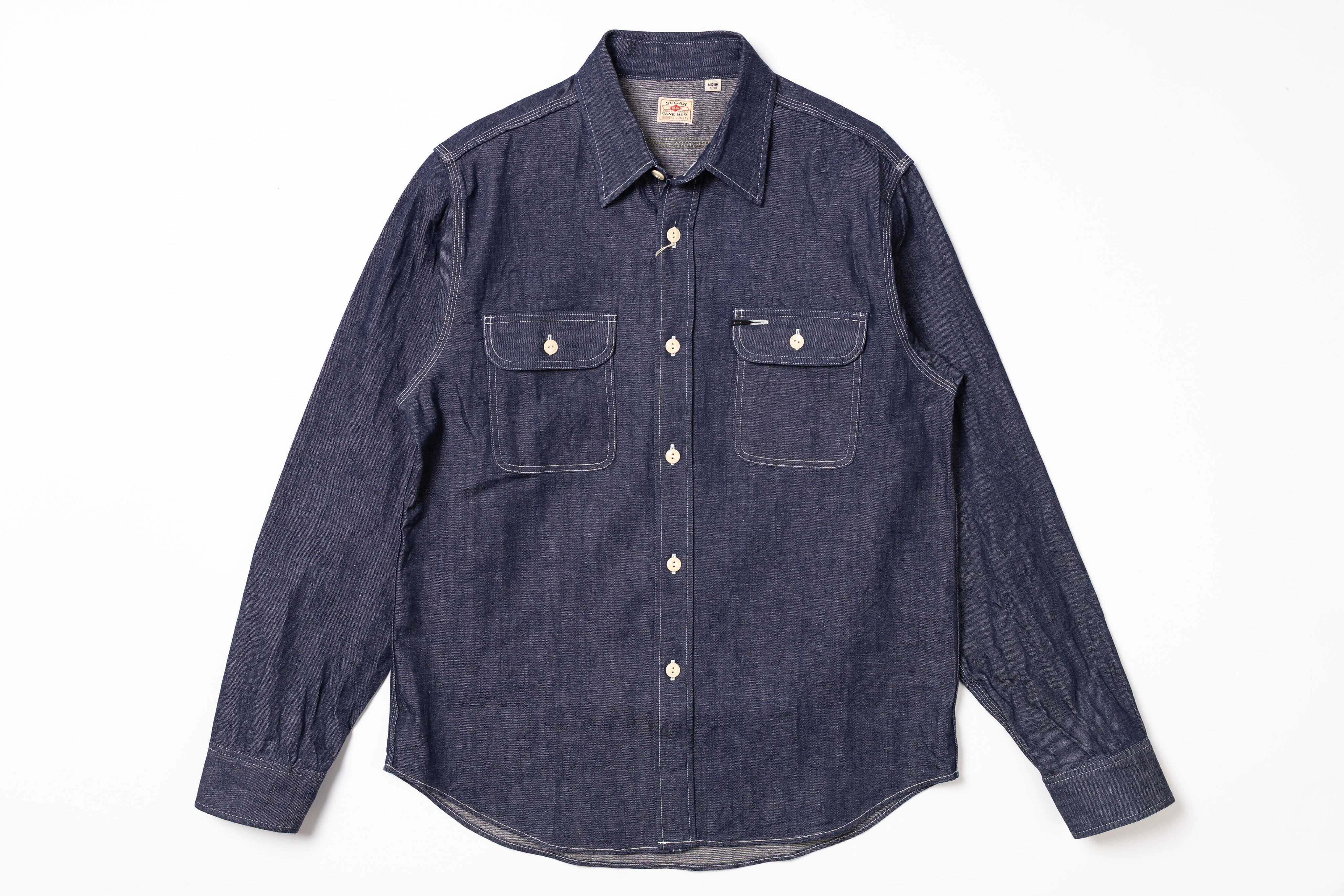 Blue denim shirt with two front pockets on a white background