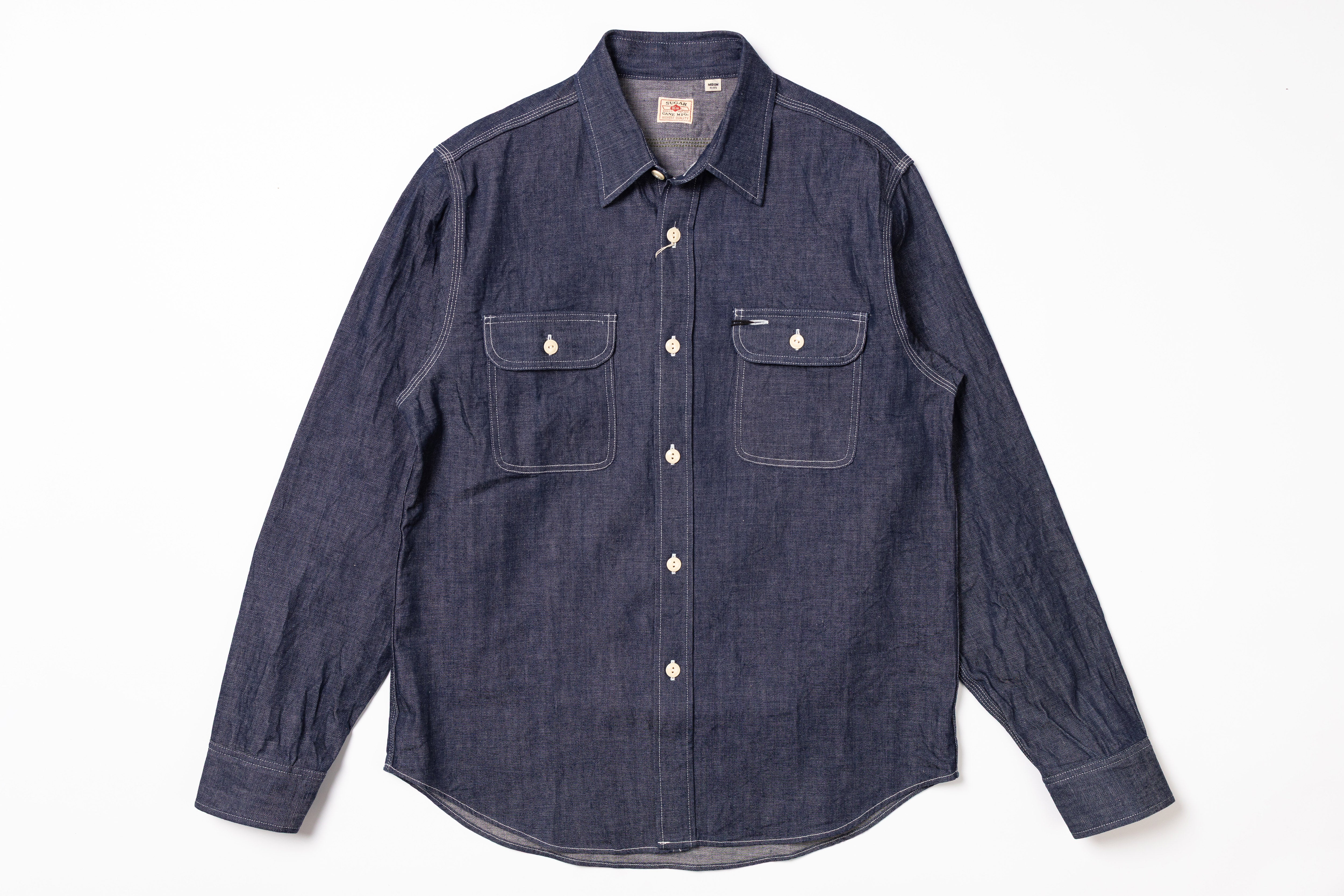 Blue denim shirt with two front pockets on a white background