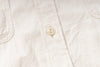 Close-up of a white button on a textured fabric background