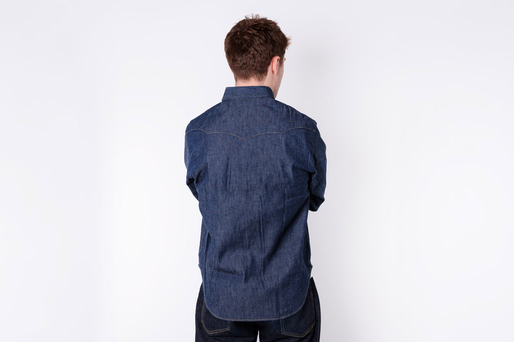 Person wearing a blue denim shirt against a white background