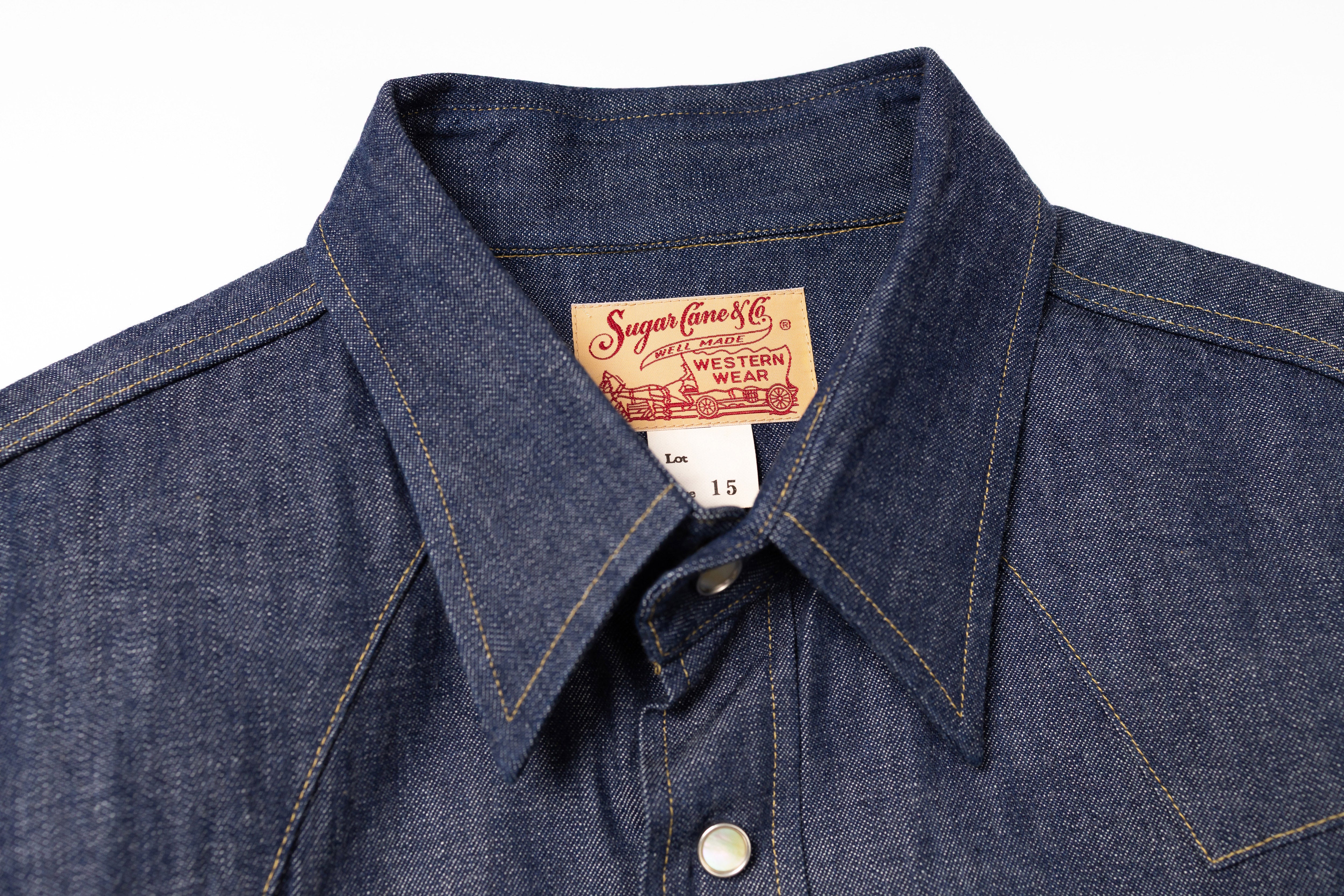 Close-up of a denim shirt with a brand label on a white background