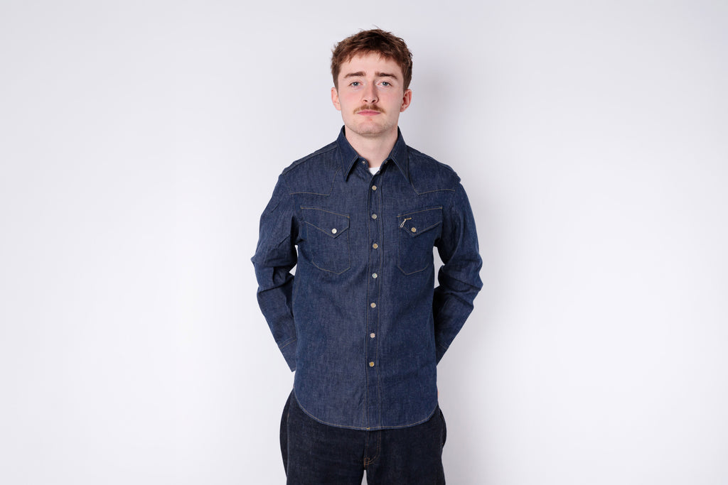 Man wearing a blue denim shirt against a white background