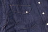 Close-up of a blue denim shirt with a pocket and buttons.