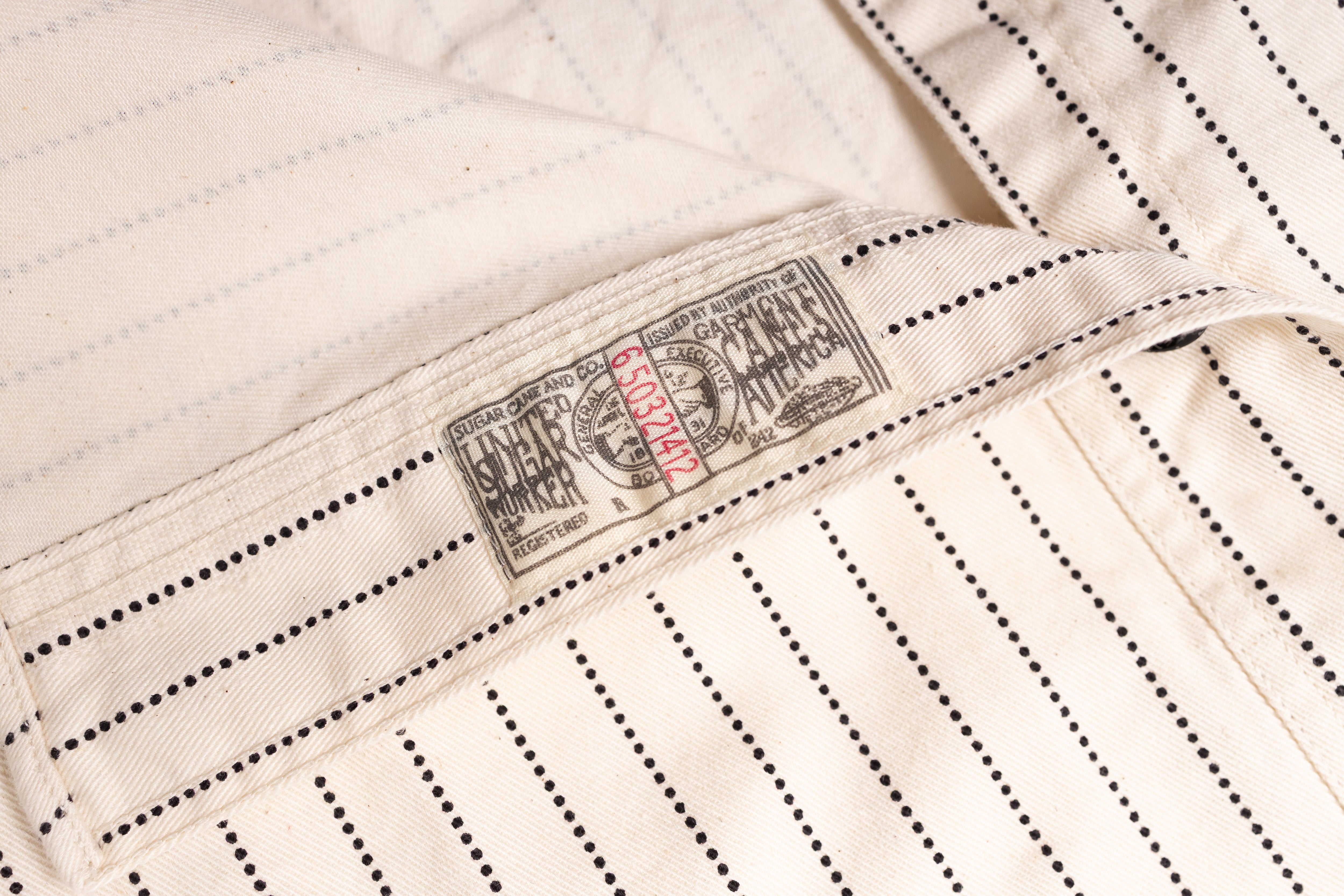 Close-up of a beige fabric with a brand label on a white background