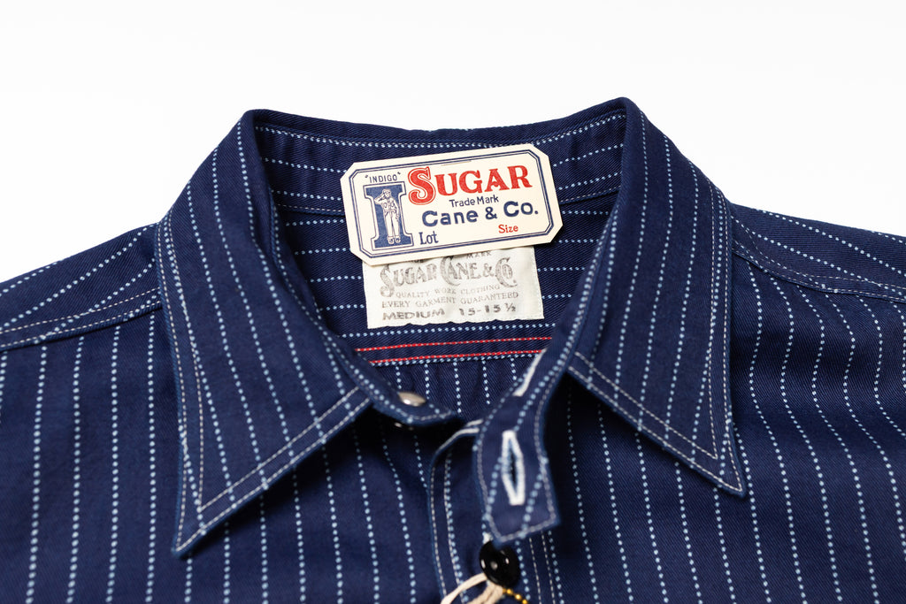 Navy pinstripe shirt with a visible brand label on a white background