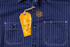 Navy pinstripe shirt with a yellow tag on a dark background