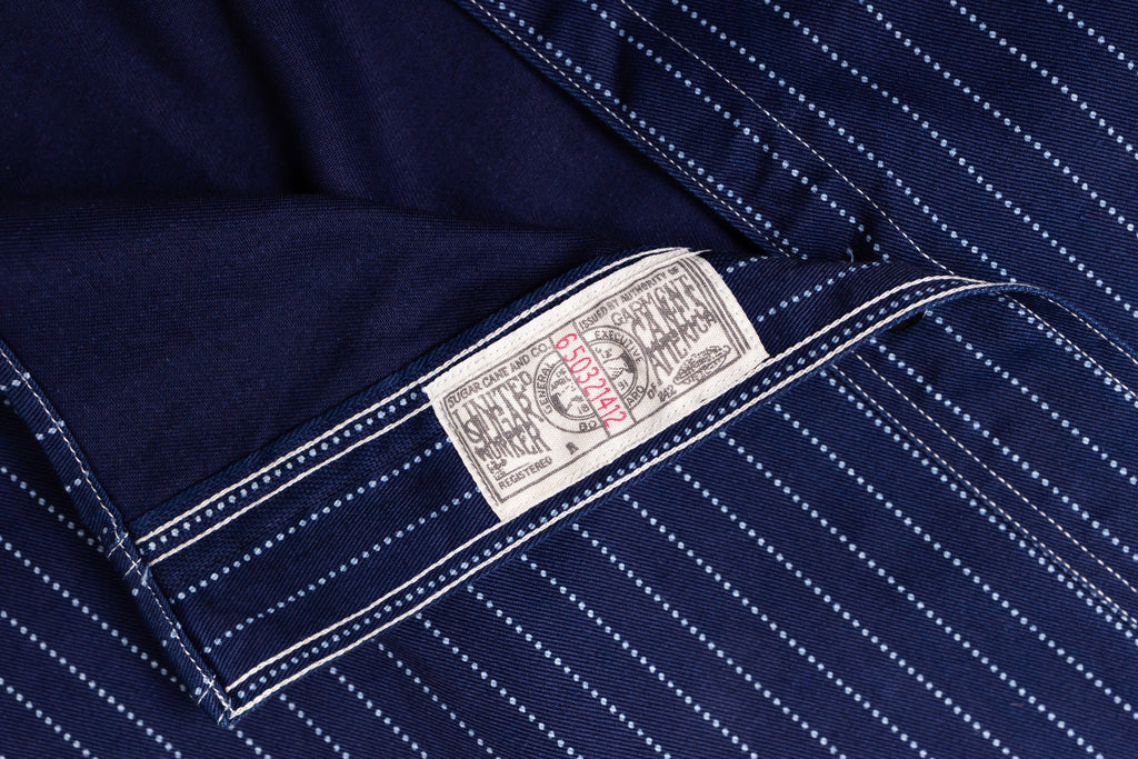 Close-up of a navy blue shirt with a brand label on a matching background
