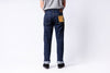 Person wearing blue jeans with a visible brand label on a white background