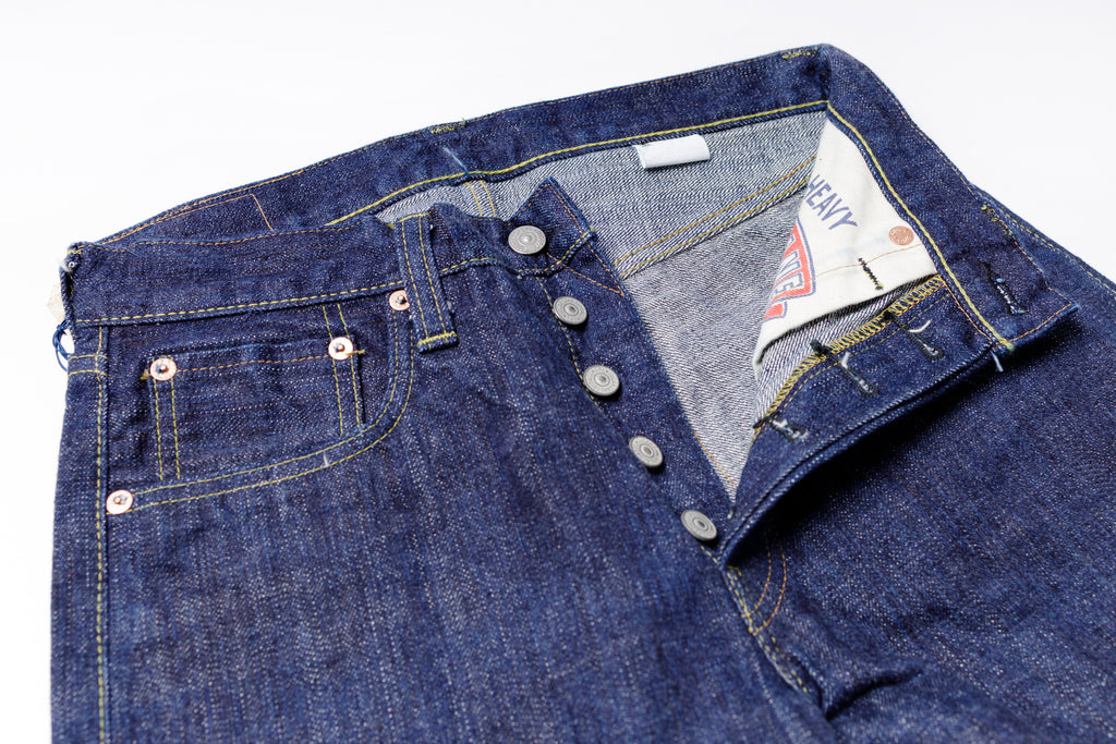 Close-up of a folded pair of blue jeans with a Levi's tag on a white background