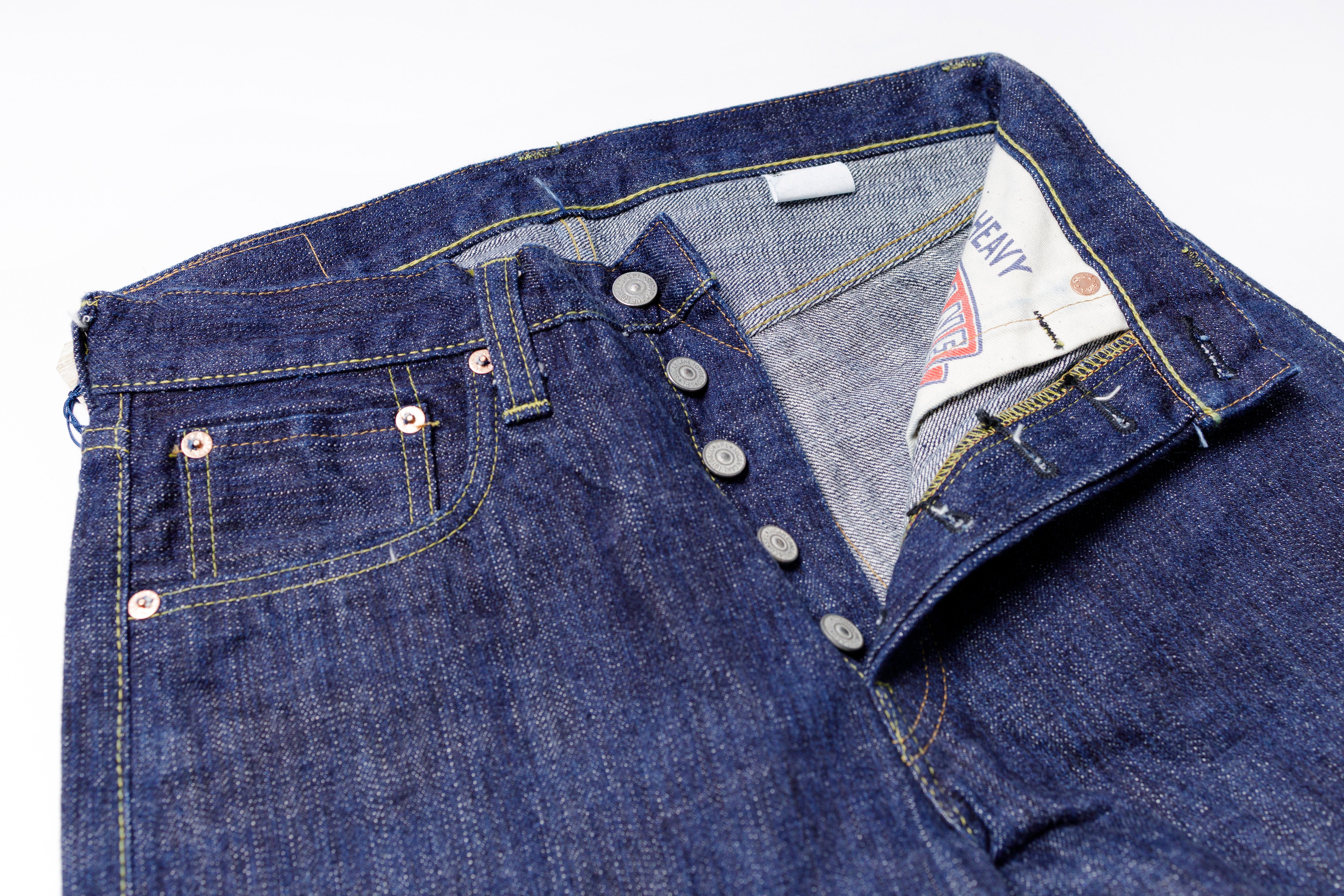 Close-up of a folded pair of blue jeans with a Levi's tag on a white background