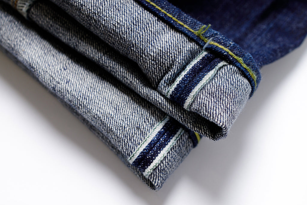 Folded blue jeans on a white background