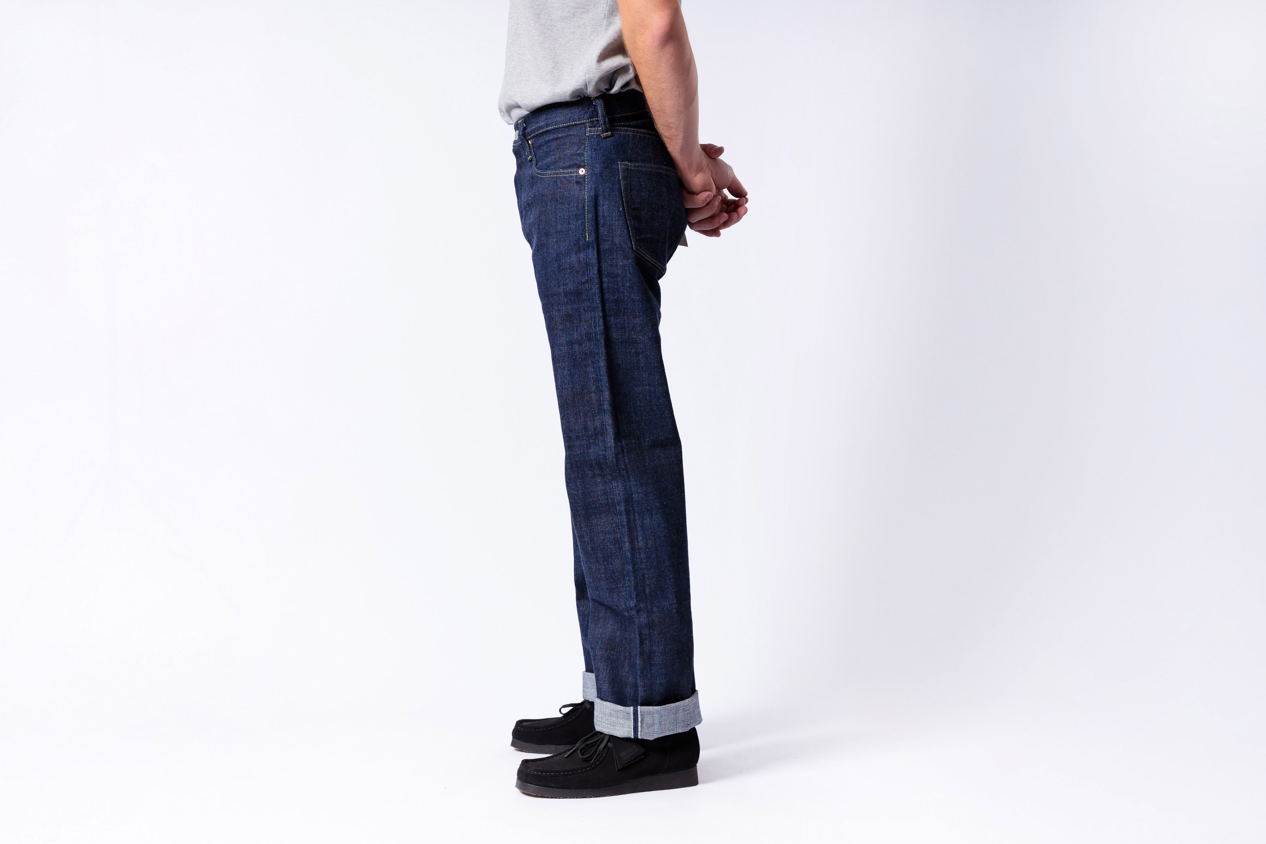 Person wearing dark blue jeans on a white background