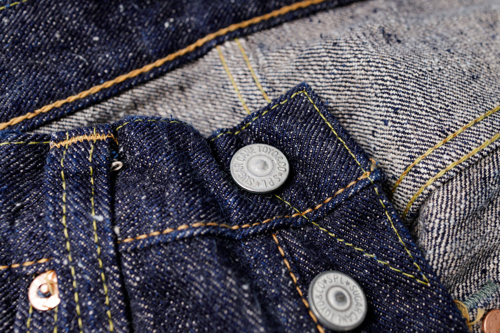Close-up of a button on a denim jacket with a blurred background