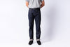 Person wearing dark blue jeans and a gray shirt on a white background