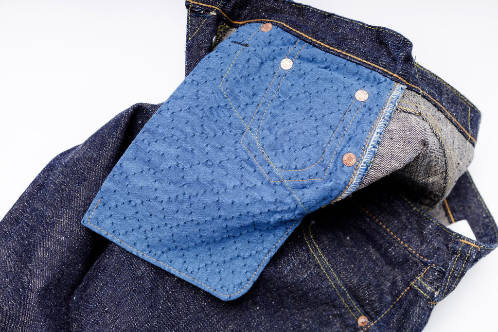 Close-up of blue denim jeans with a white background