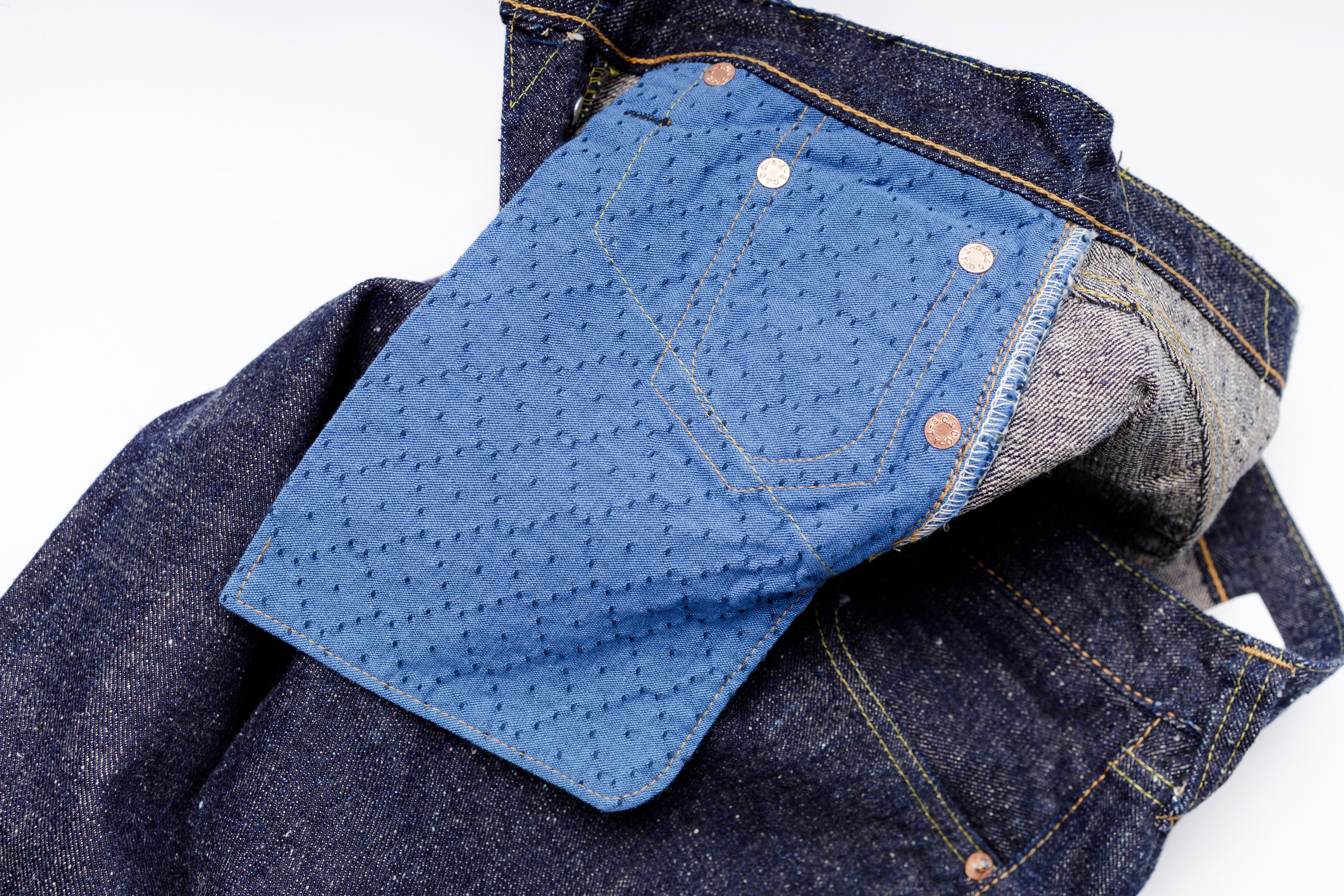 Close-up of blue denim jeans with a white background