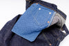 Close-up of blue denim jeans with a white background