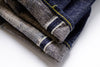 Stack of folded denim jeans on a white background