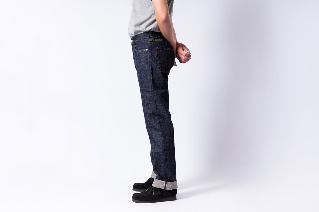Person wearing dark blue jeans on a white background