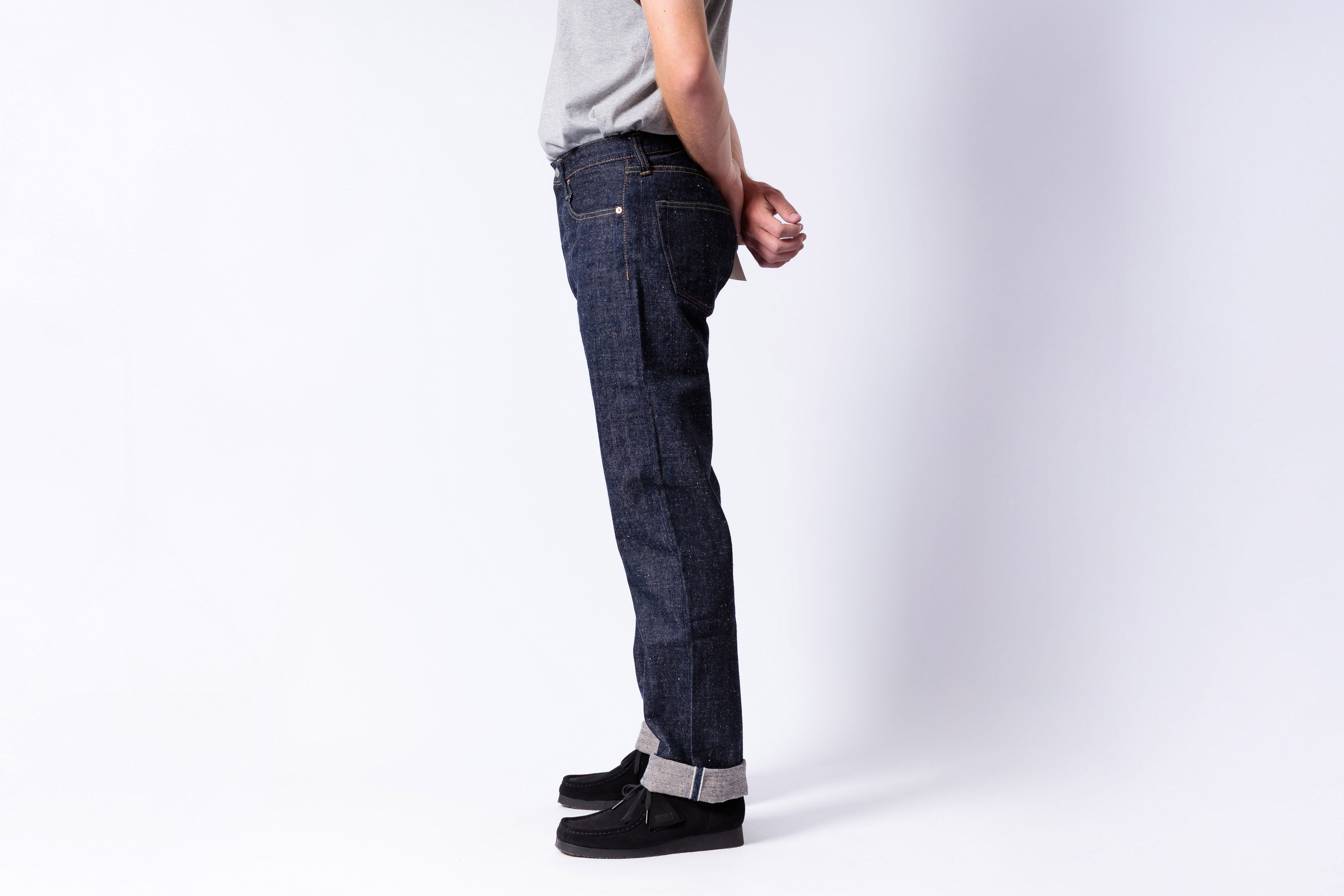 Person wearing dark blue jeans on a white background