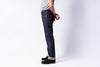 Person wearing dark blue jeans on a white background