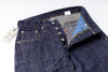 Close-up of a pair of blue jeans with a visible brand tag on a white background