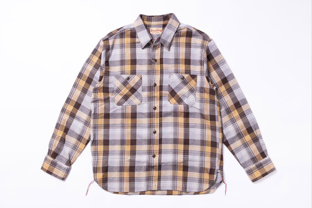 Plaid shirt with a pattern of brown, yellow, and gray on a white background