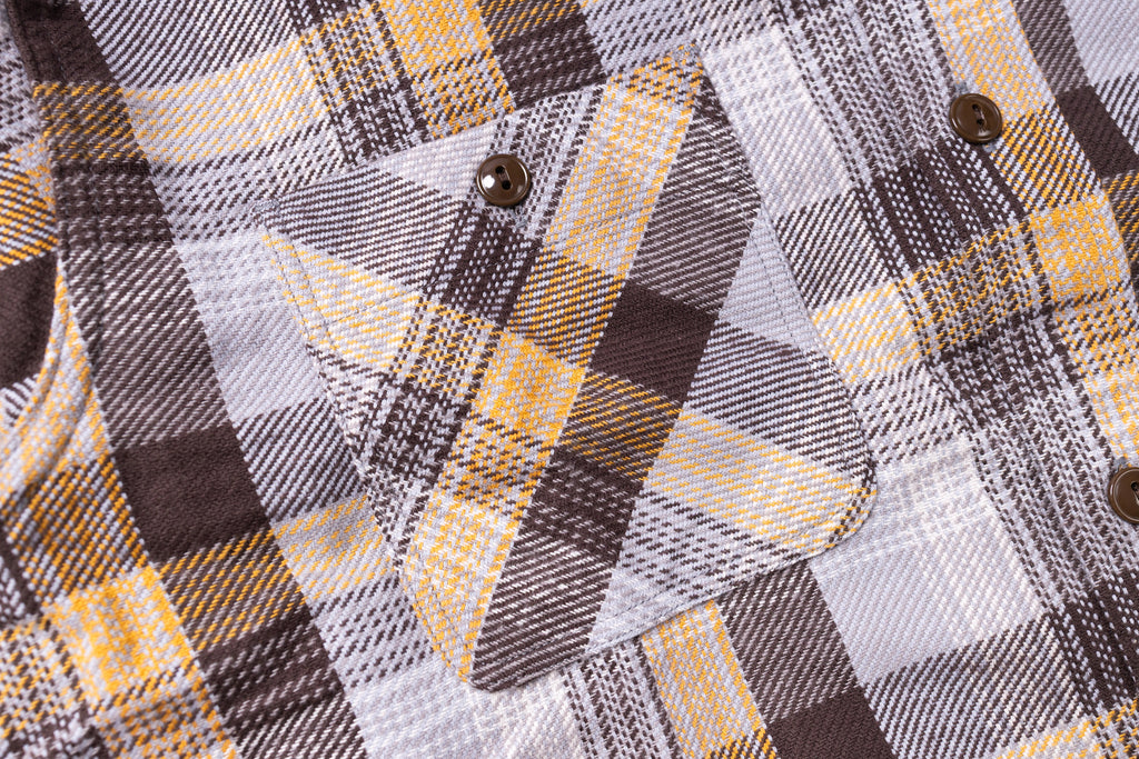 Close-up of a plaid shirt with yellow, black, and white pattern