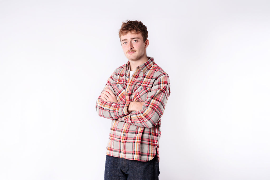 Man wearing a plaid shirt against a white background