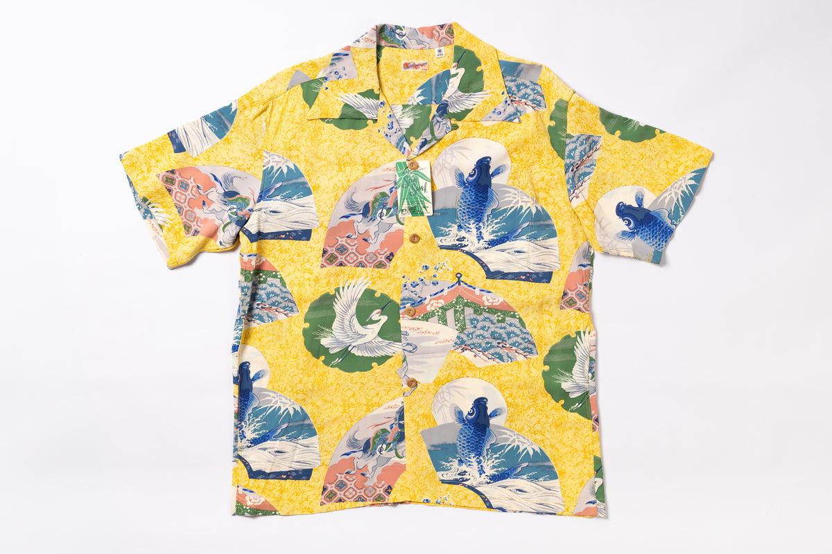 A yellow short-sleeve button-up camp shirt with a Japanese wave and koi fish print, laid flat on a white background.