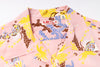 A close-up of a pink short-sleeve camp collar shirt with a colorful print of yellow, blue, and brown tropical birds and abstract patterns. The brand label 'Sun Surf' is visible inside the collar.