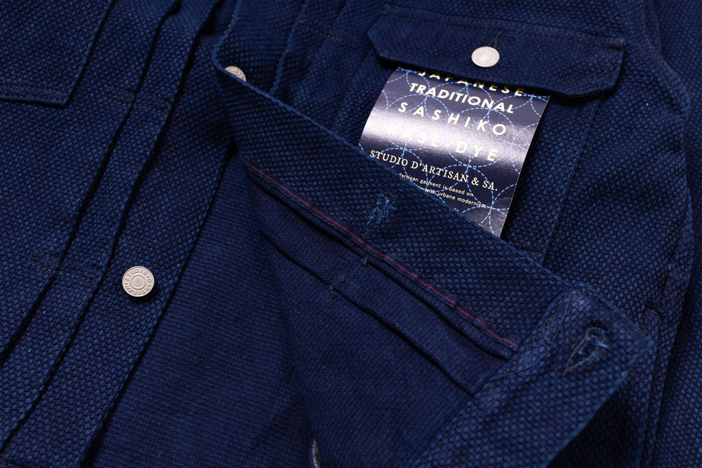 Close-up of a navy blue shirt with a brand label on a matching background