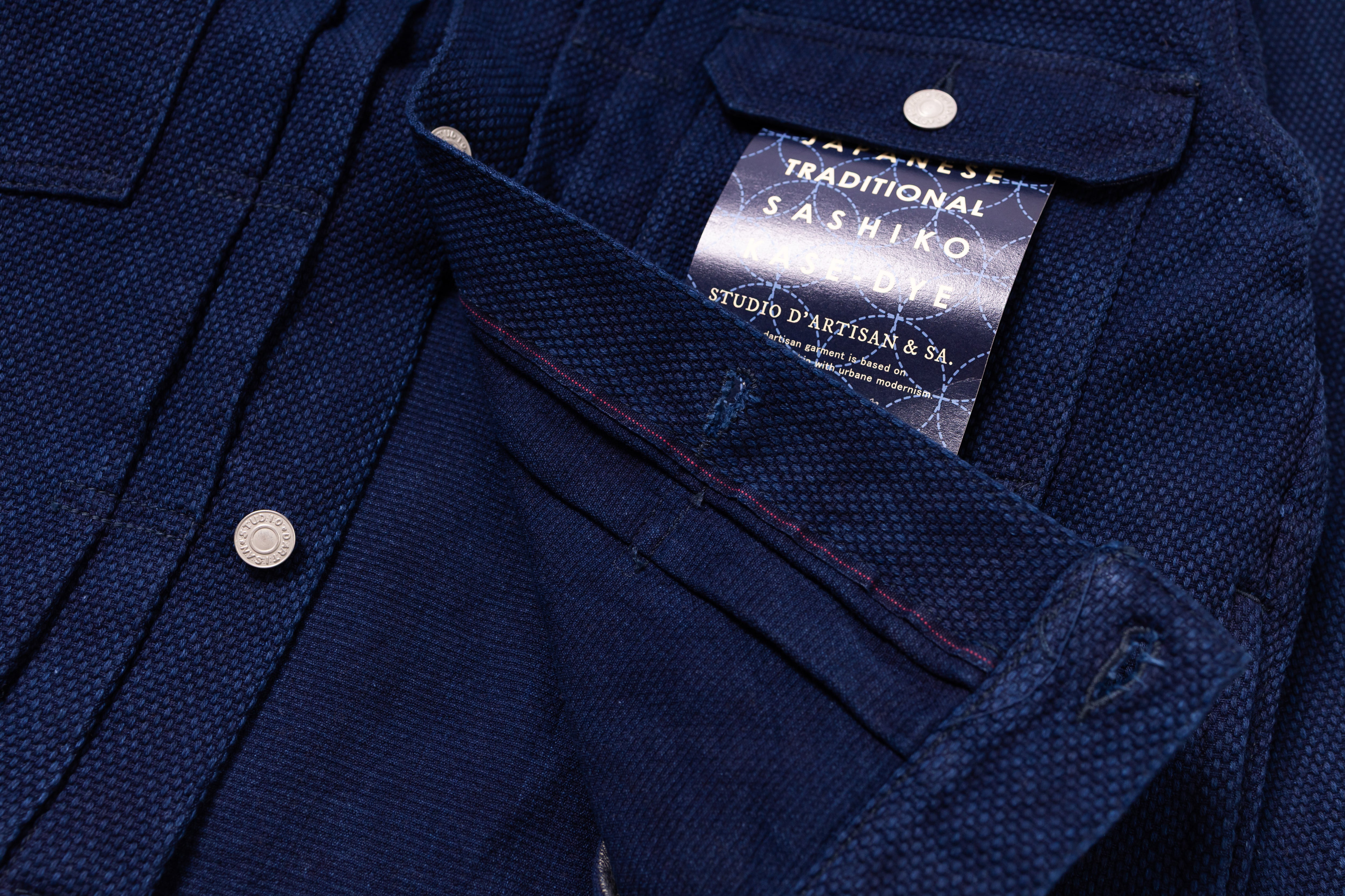 Close-up of a navy blue shirt with a brand label on a matching background