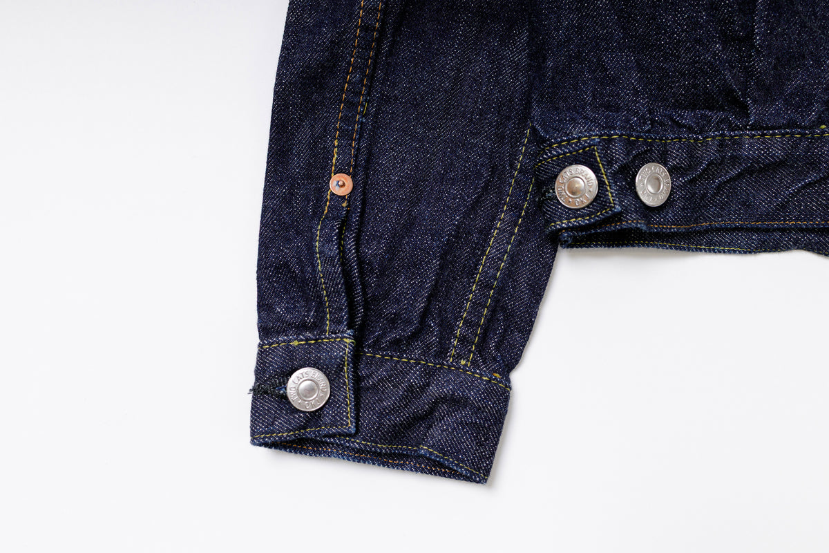 Close-up of a blue denim jacket with buttons on a white background