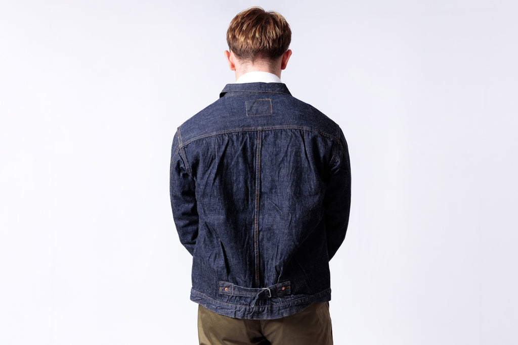 Person wearing a blue denim jacket on a white background