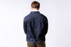 Person wearing a blue denim jacket on a white background