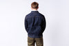 Man wearing a dark blue denim jacket on a white background