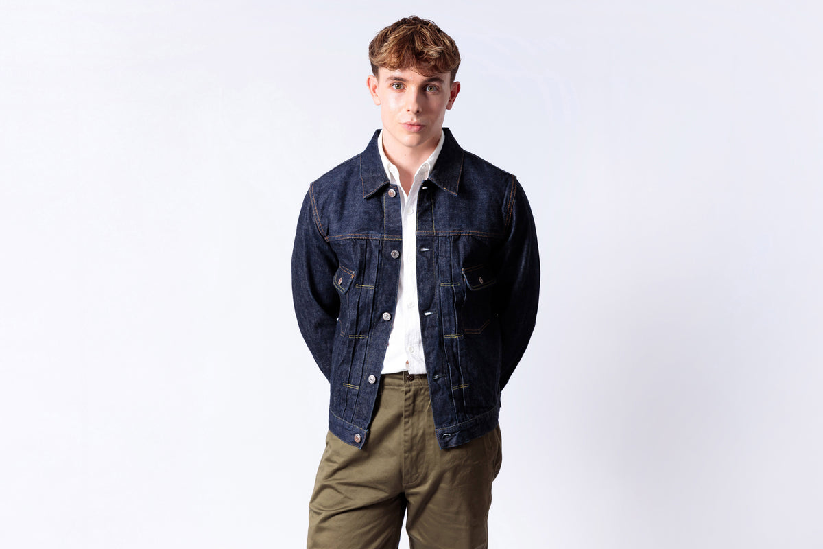 Man wearing a denim jacket and white shirt on a white background