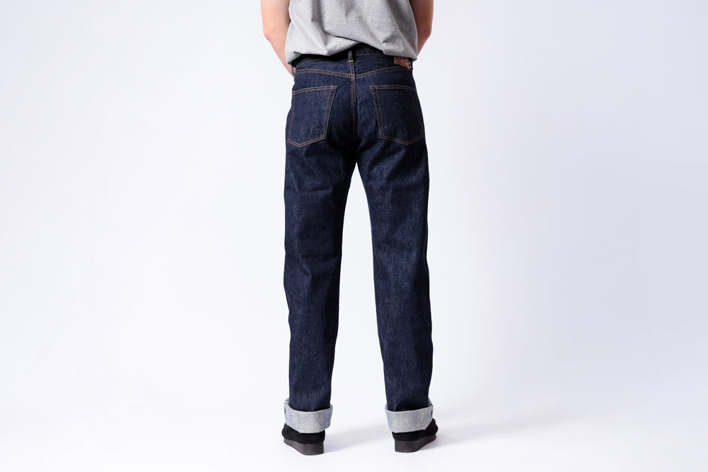 Person wearing dark blue jeans on a white background