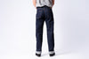 Person wearing dark blue jeans on a white background