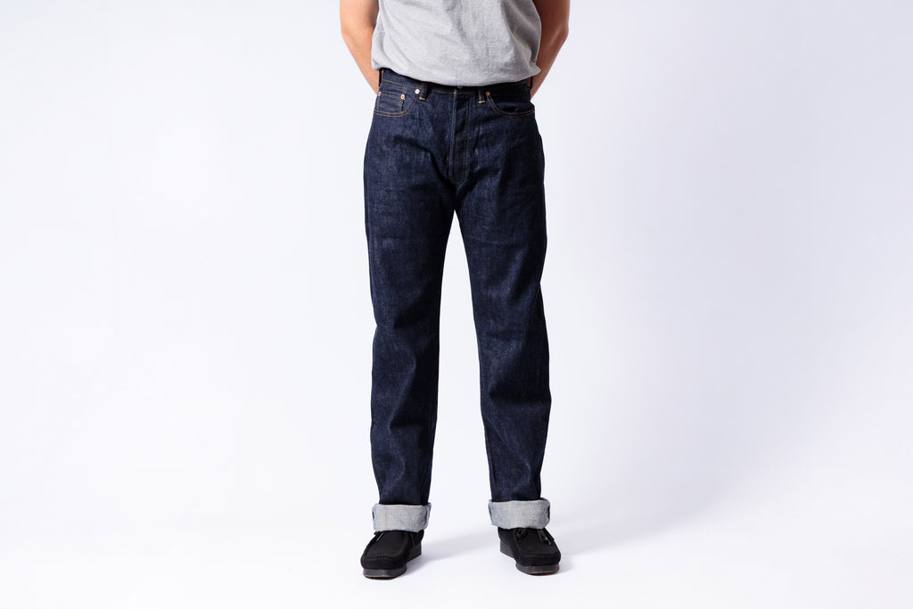 Person wearing dark blue jeans on a white background