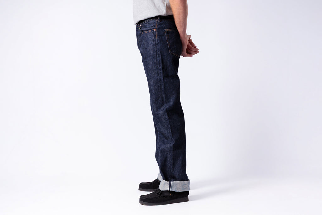 Person wearing dark blue jeans on a white background