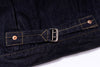Close-up of dark denim fabric with a buckle and buttons on a white background