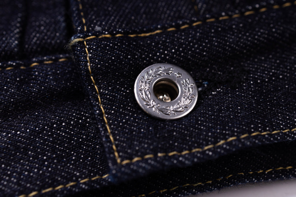 Close-up of a button on a denim fabric background