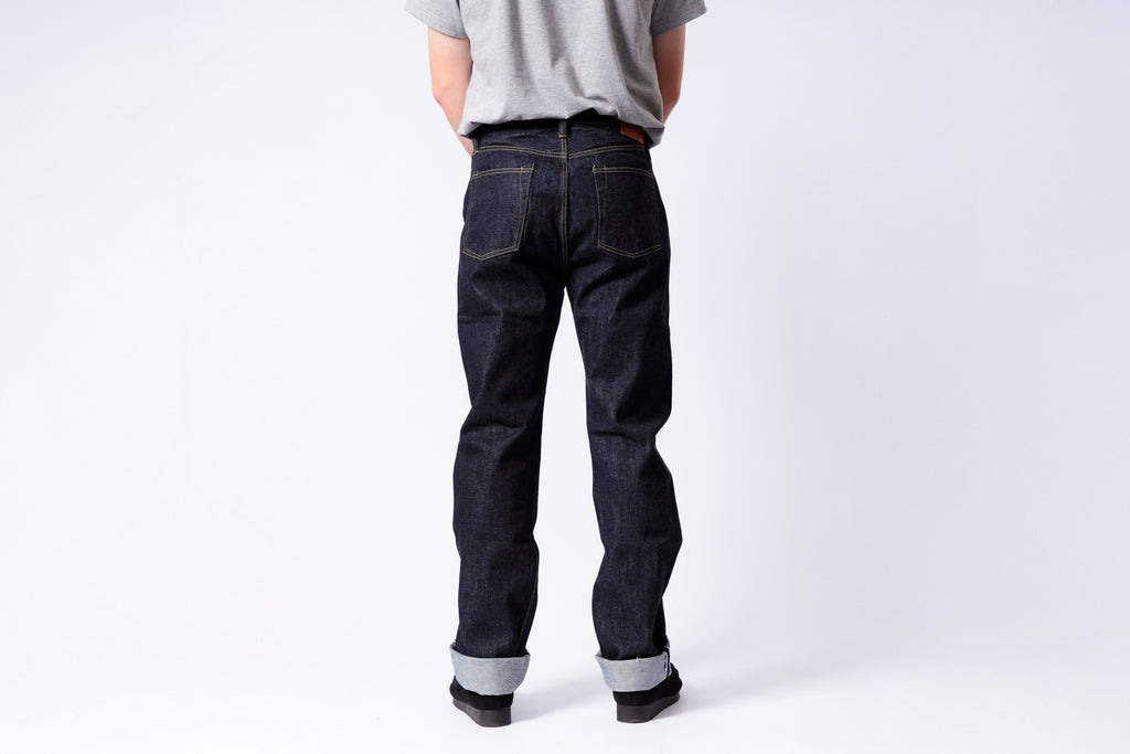 Person wearing dark blue jeans on a white background