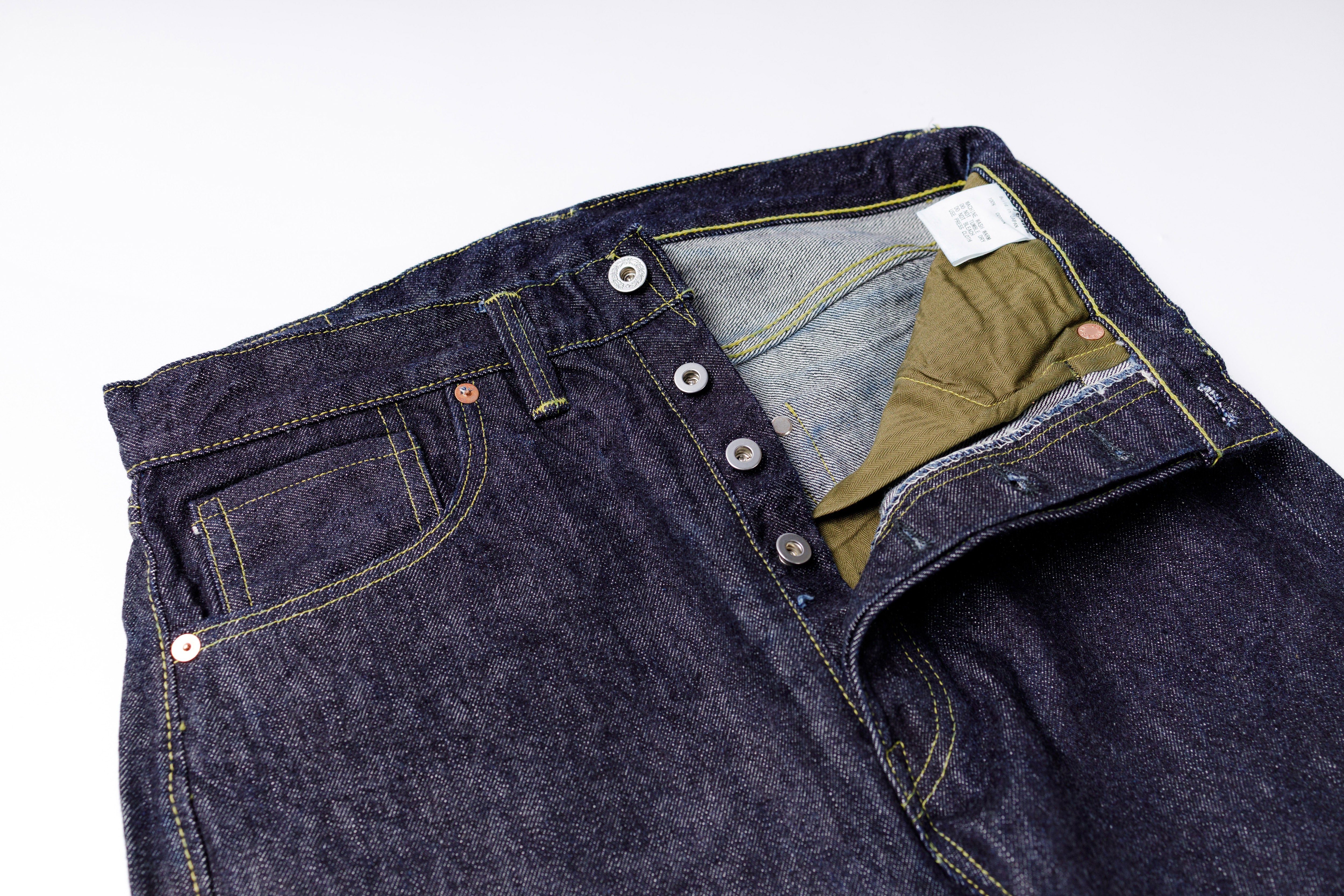 Close-up of a pair of dark blue jeans with a white background