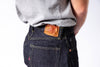 Person wearing jeans with the brand logo on the pocket against a white background