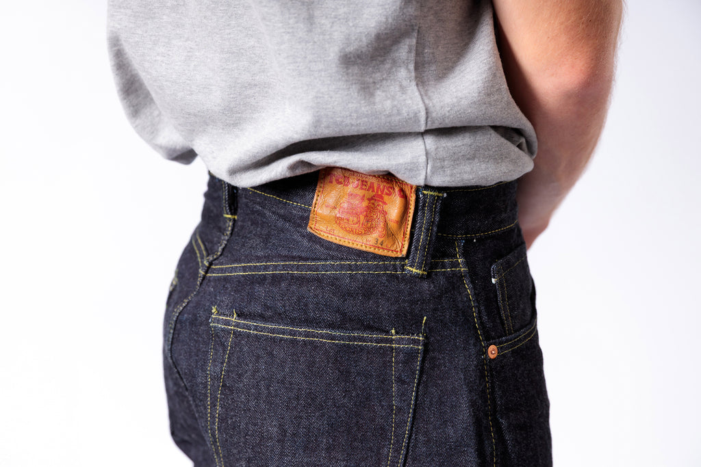 Person wearing Levi's jeans with the brand logo on the pocket against a white background
